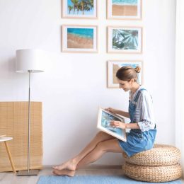 Femme qui met des tableaux sur le mur